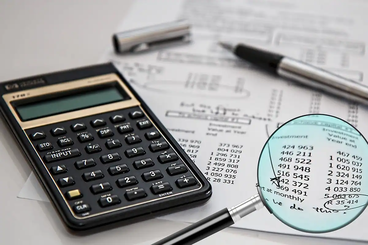 Calculator, lupă și tabel cu cifre folosite la verificarea situației fiscale
