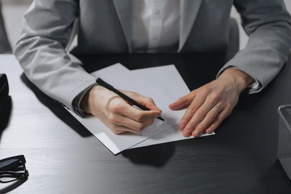 Persoană la costum care semnează o declarație de renunțare la moștenire