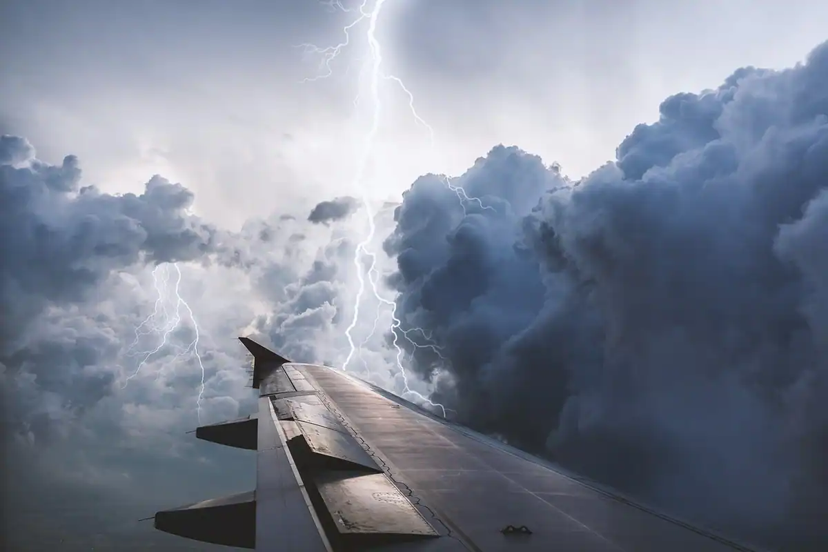 Aripa unui avion deasupra norilor de furtună, pe drumul spre casă